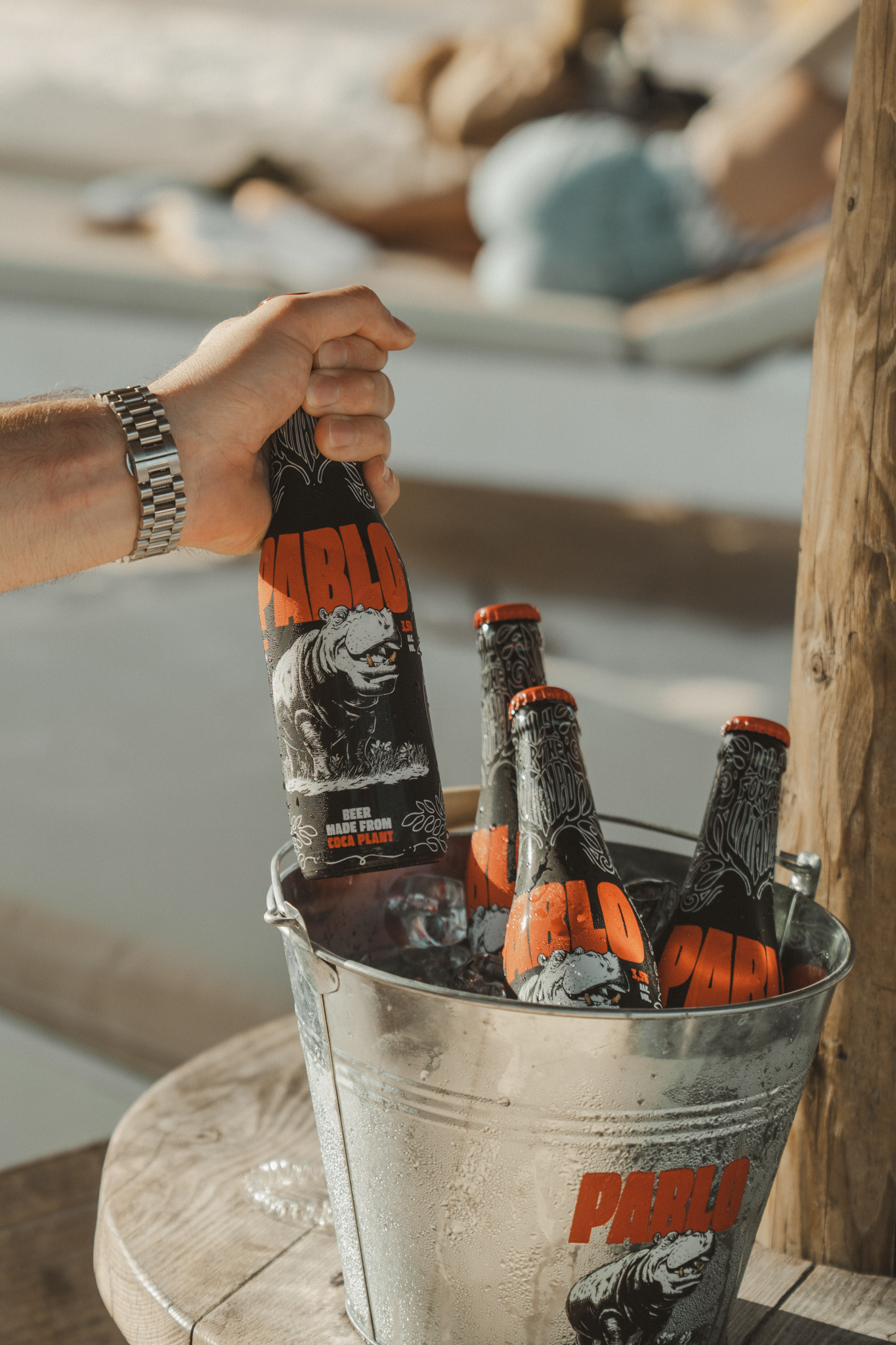 Een fles Pablo Beer boven flessen die in een ijsemmer worden gekoeld.