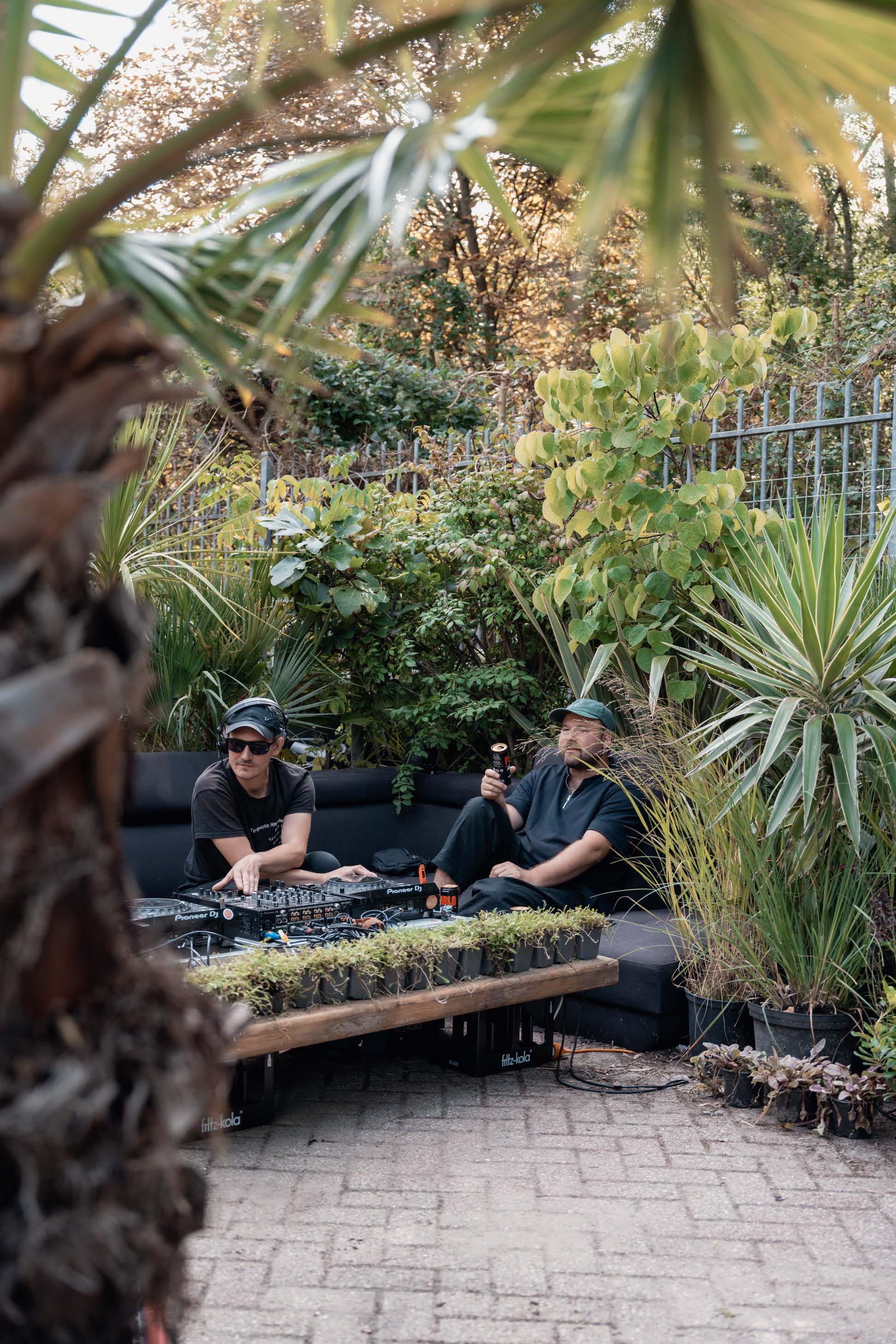Twee DJ's draaien in een tuin naast blikken Pablo Beer.
